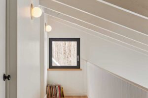 Vzdušná chodba v horním patře ukazuje, jak rekonstrukce přinesla do domu více denního světla a klidný, minimalistický výraz.