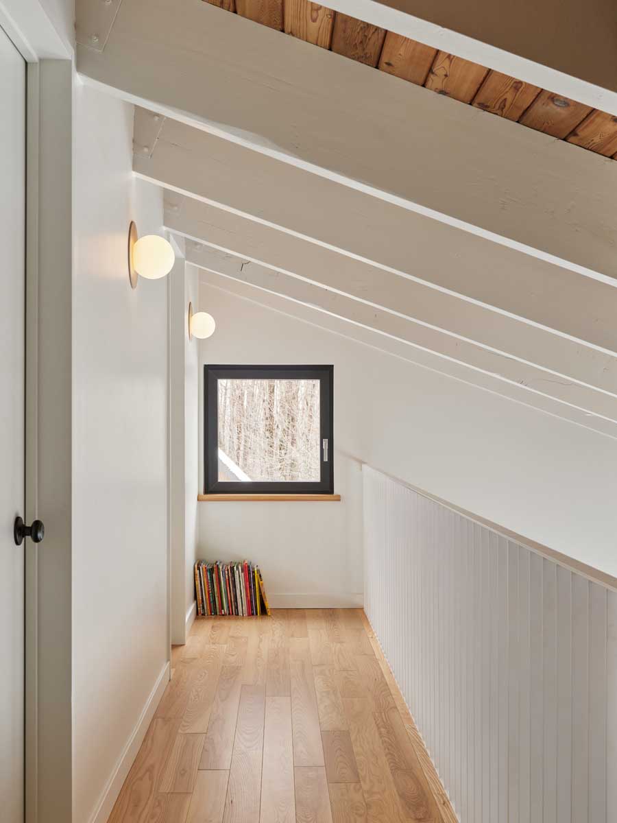 Vzdušná chodba v horním patře ukazuje, jak rekonstrukce přinesla do domu více denního světla a klidný, minimalistický výraz.