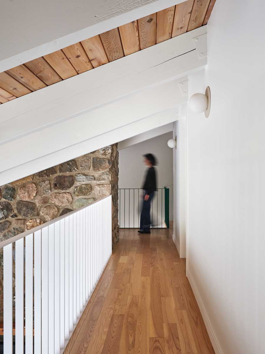 Moderní lávka nad obytným prostorem nechává vyniknout původnímu kamennému zdivu, které se stalo jedním z nejcennějších prvků rekonstrukce.