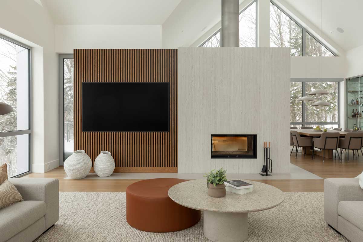 Denní zóna domu La Croix propojuje jídelnu, krb i obývací část tak, aby se zde spojovaly světlo, pohledy a rytmus života