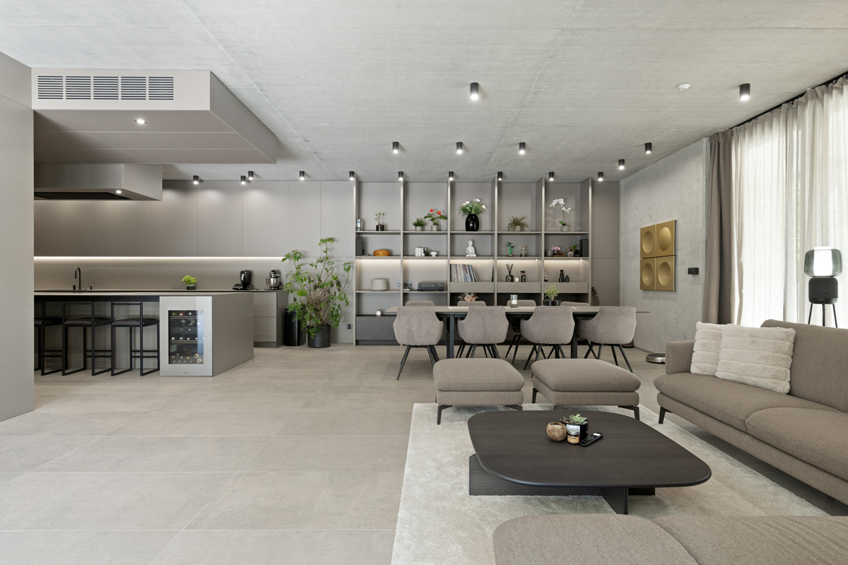 Propojení kuchyně, jídelny a obývací části v jednotném minimalistickém stylu.