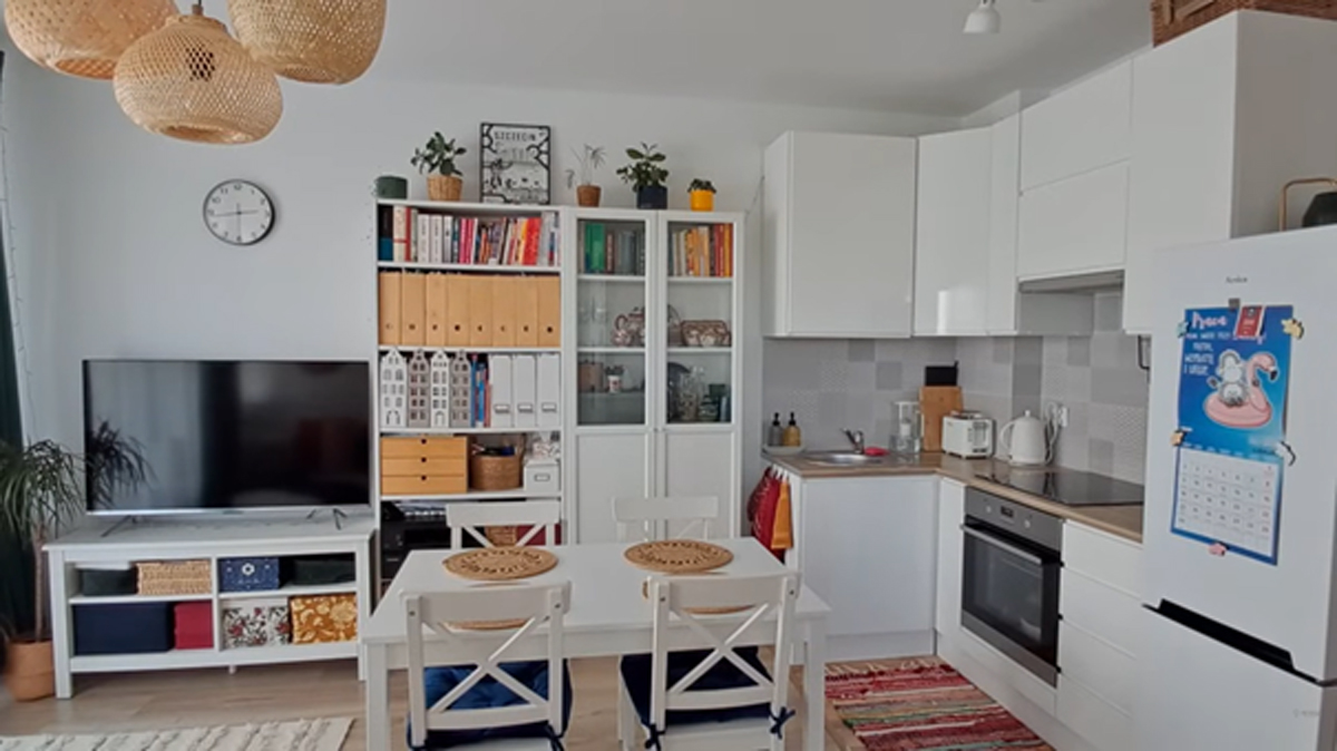 Světlý otevřený obývací prostor s kuchyňským koutem a jídelním stolem.