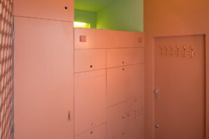 Minimalistický interiér s integrovaným úložným systémem a pastelovými barvami.