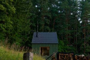 Praktický přístřešek na dřevo a pečlivě srovnaná polínka dotvářejí obraz klidu a soběstačnosti – estetika i funkčnost v jednom.