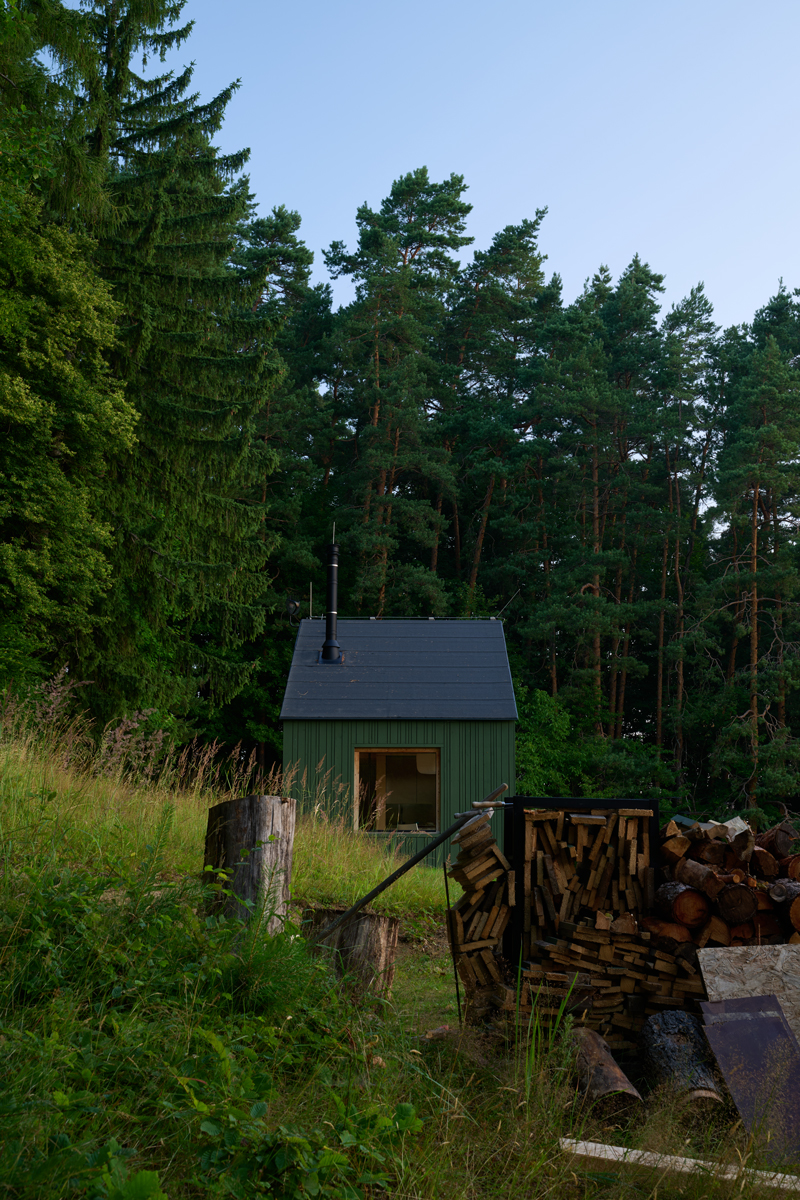 Praktický přístřešek na dřevo a pečlivě srovnaná polínka dotvářejí obraz klidu a soběstačnosti – estetika i funkčnost v jednom.