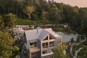 Letecký pohled na dům La Croix odhaluje jeho půdorys ve tvaru kříže a harmonické propojení s okolní krajinou