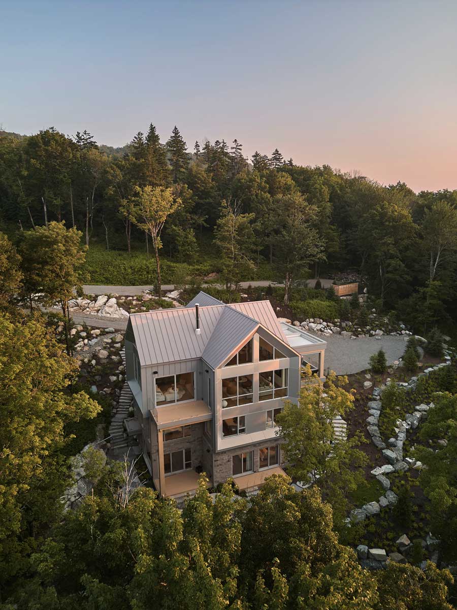 Letecký pohled na dům La Croix odhaluje jeho půdorys ve tvaru kříže a harmonické propojení s okolní krajinou