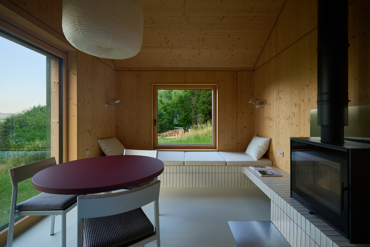 Elegantní kontrast vínového stolu, šedých židlí a světlého dřeva dodává interiéru charakter. Každý detail má svou funkci – nic navíc, nic zbytečného.