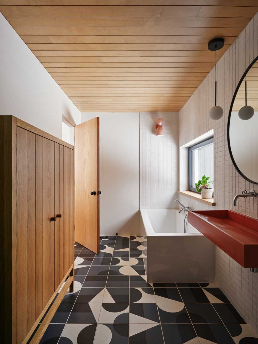 Zrekonstruovaná koupelna spojuje přírodní materiály s hravou geometrií dlažby, která přináší do tradiční horské chaty moderní charakter.