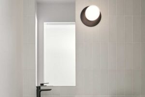 Minimalistické umyvadlo s obloukovým zrcadlem přináší do domu současný design, aniž by narušovalo jeho útulnou atmosféru.