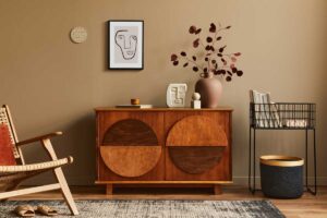 Osobitý interiérový koutek s výraznou komodou, designovými dekoracemi a teplými zemitémi tóny.
