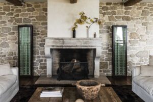 Pečlivě restaurovaný historický krb začleňující se do interiéru tvořeného materiály, které stárnou s grácií.