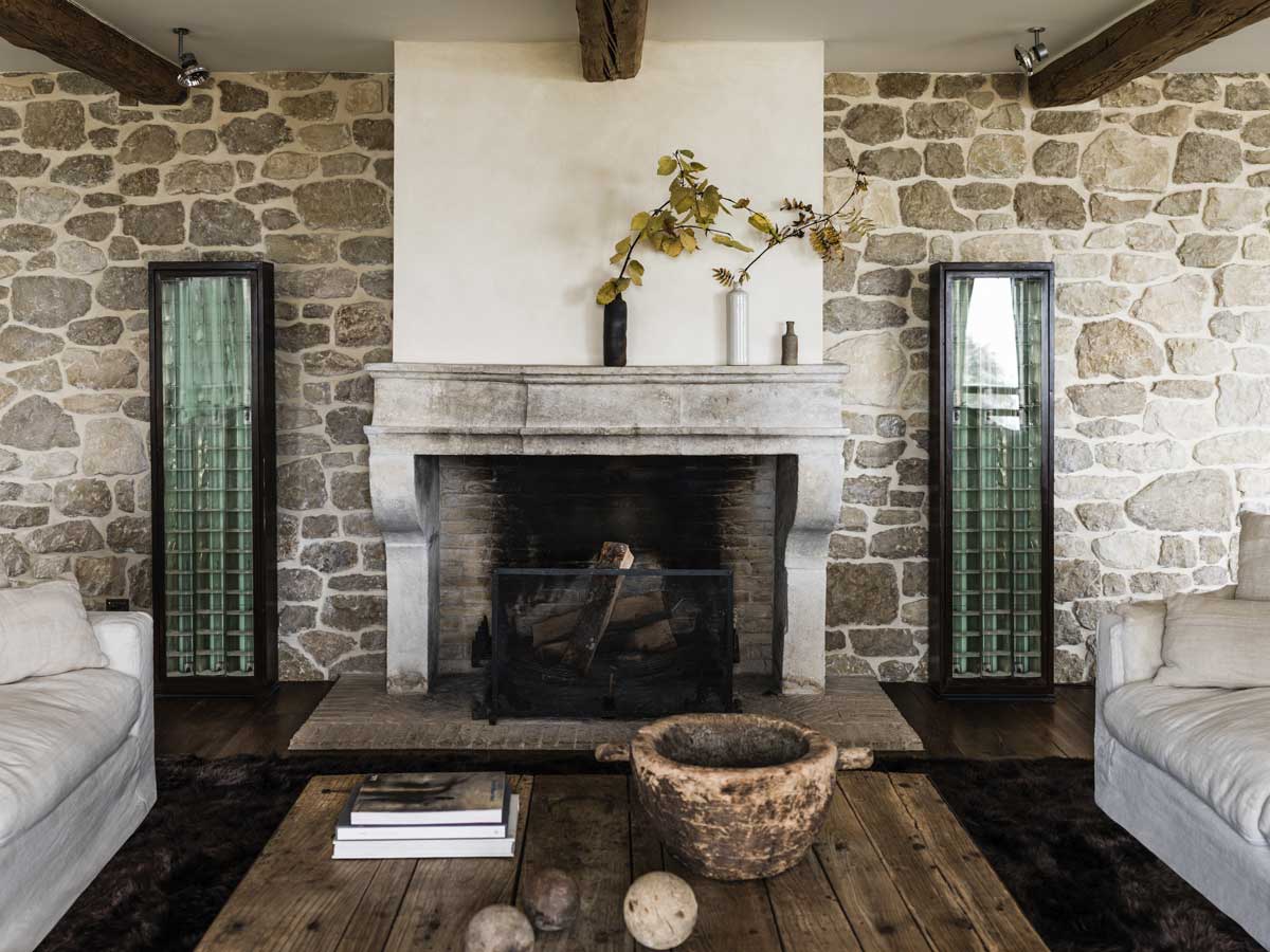 Pečlivě restaurovaný historický krb začleňující se do interiéru tvořeného materiály, které stárnou s grácií.