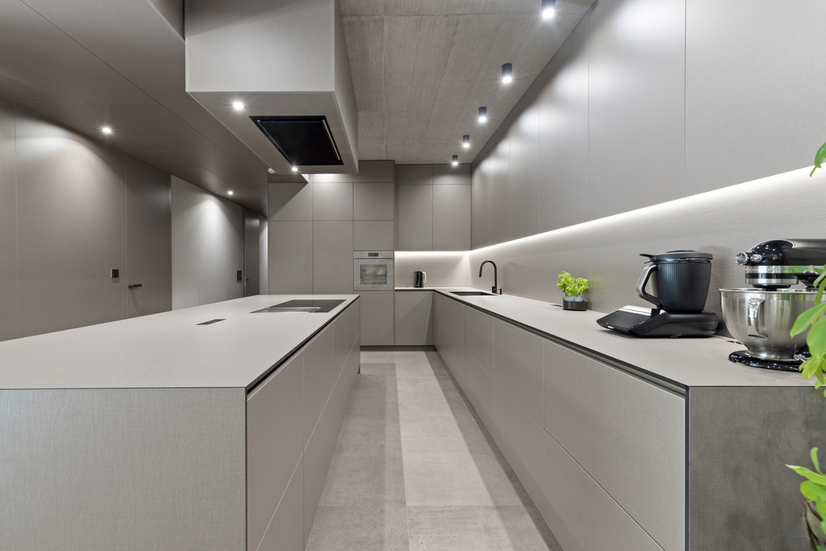 Moderní kuchyň v šedém matu s decentním podsvícením a čistým geometrickým řešením.