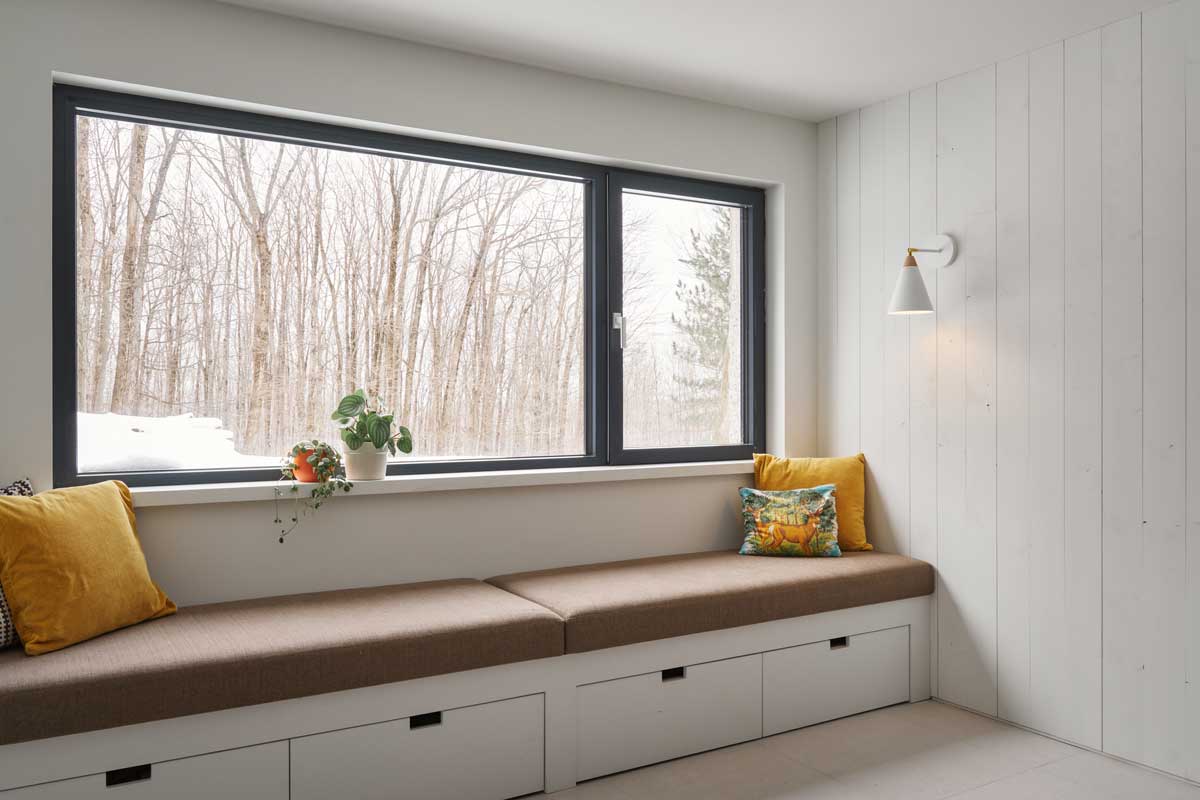 Další okenní zákoutí s měkkými podsedáky dokazuje, jak důležitou roli hraje denní světlo v nově navržených obytných prostorech.