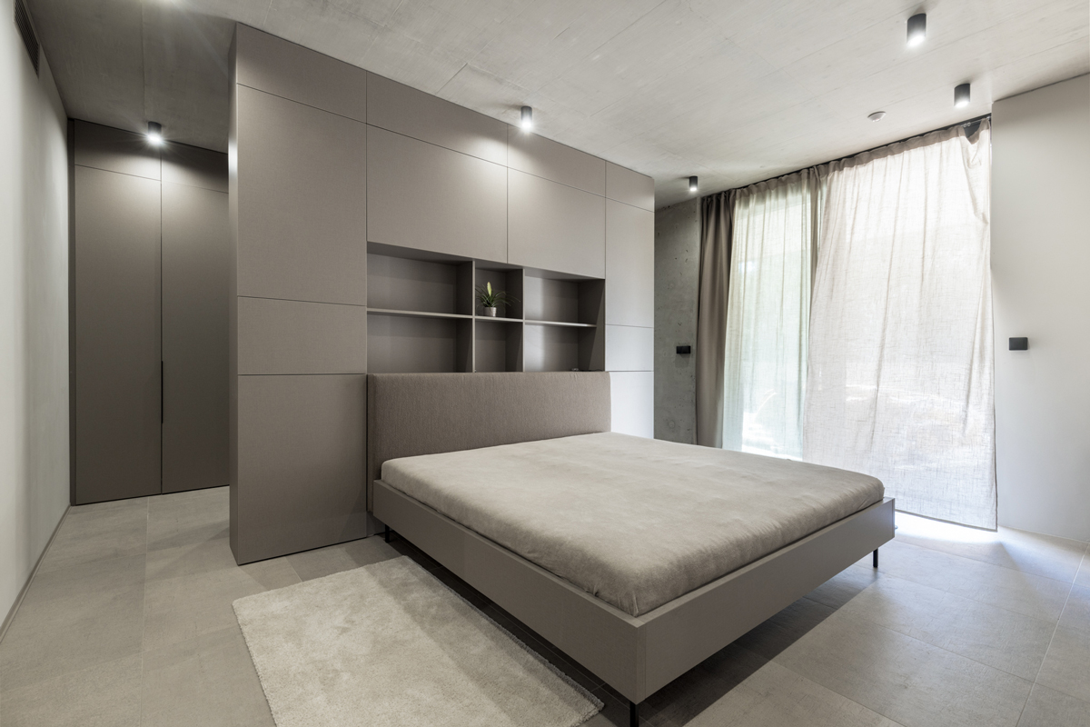 Světlá ložnice s jemnými závěsy a čistými liniemi vyzařuje přirozenou jednoduchost.