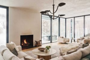 Obývací pokoj s krbem, pohodlnými sedačkami a panoramatickými okny.