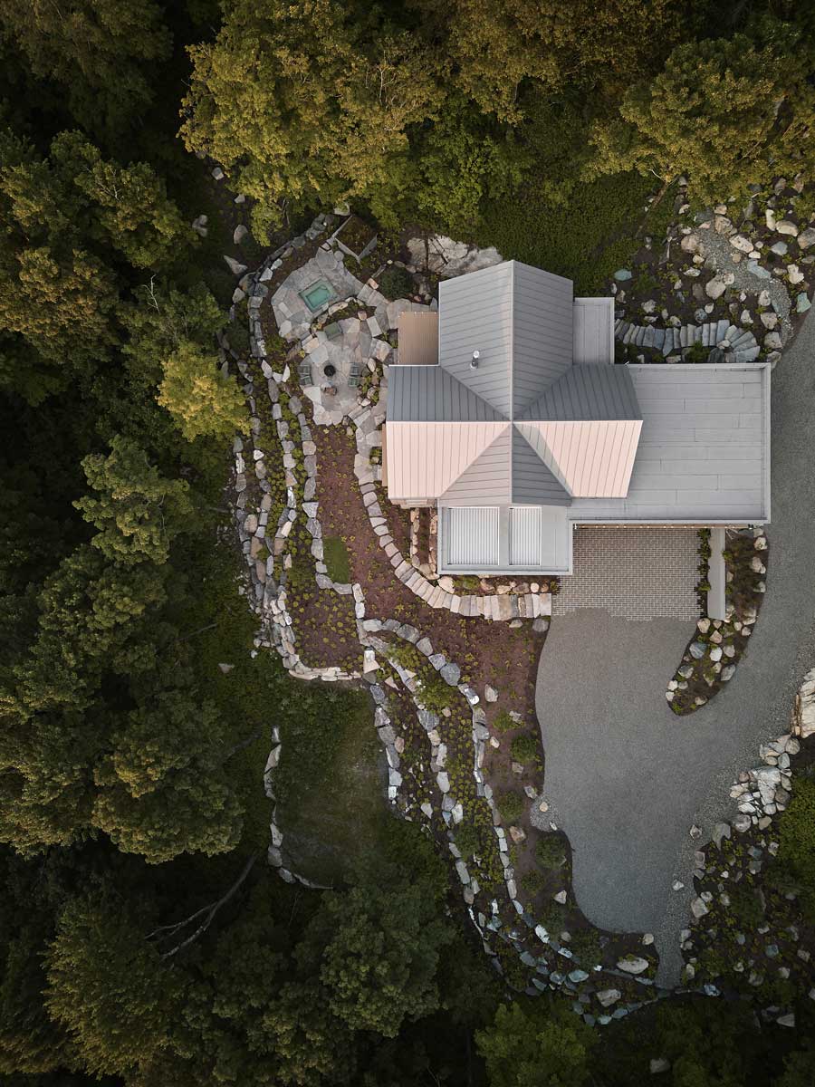 Letecký pohled na dům La Croix odhaluje křížový půdorys i terasovité kaskády zahrady sledující svah