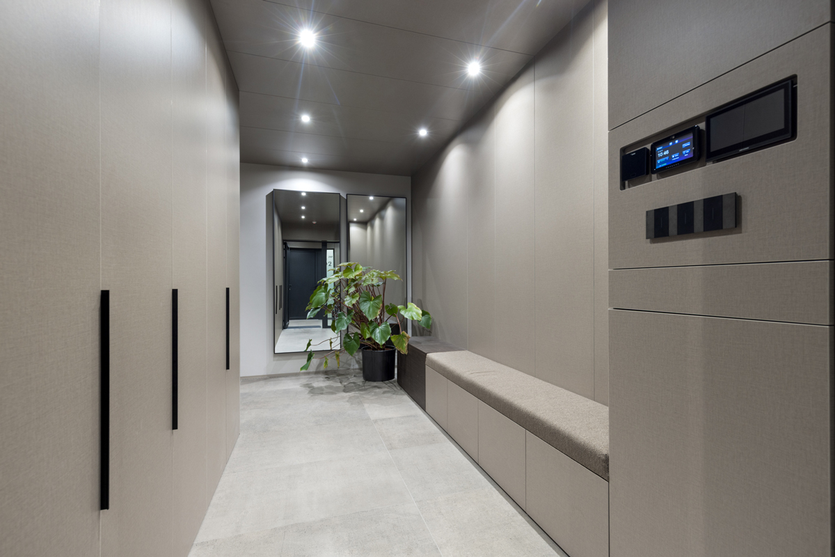 Předsíň s integrovanou lavicí, zrcadlem a decentním osvětlením.