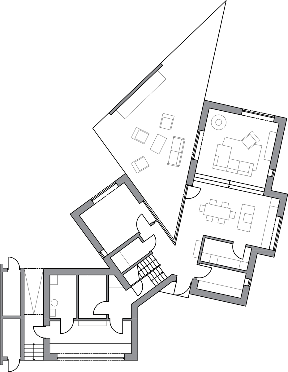 Půdorys dolního patra rodinného domu s terasu ve tvaru trojúhelníku.