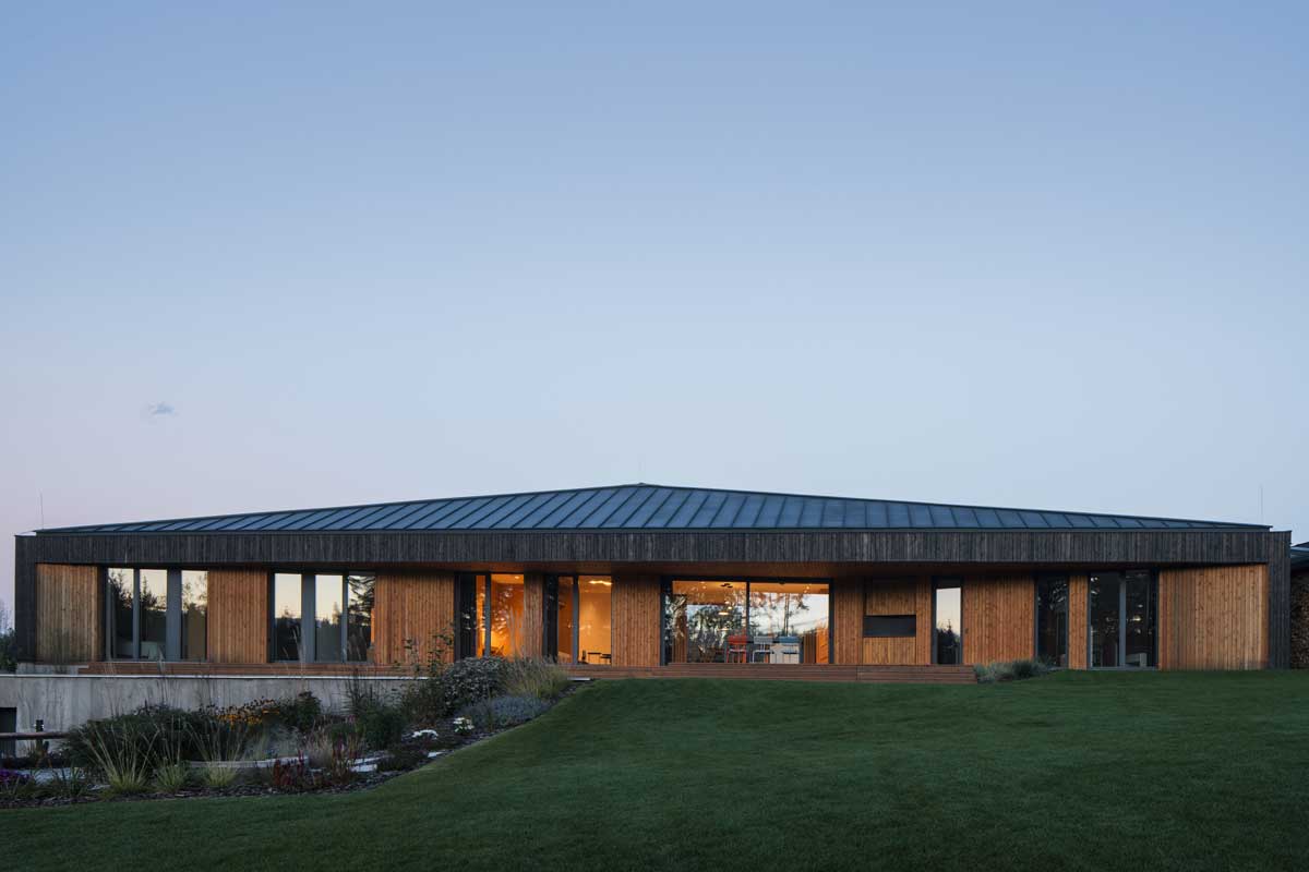 Podlouhlý rodinný dům propojený se zahradou a okolní krajinou