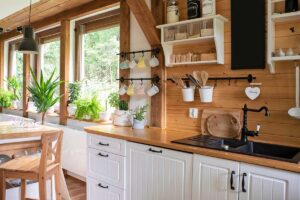 Kuchyně plná zelených rostlin, dřeva a keramických doplňků propojuje praktičnost a přírodní estetiku cottage flow.