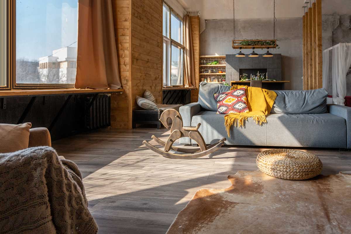 Prosluněný obývací pokoj s dřevěnými prvky, textiliemi a přírodními materiály vytváří prostor s duší a příběhem.