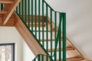 Nové jasanové schodiště se zeleným zábradlím propojuje jednotlivé úrovně domu s lehkostí a stalo se jedním z nejoblíbenějších prvků celé rekonstrukce.