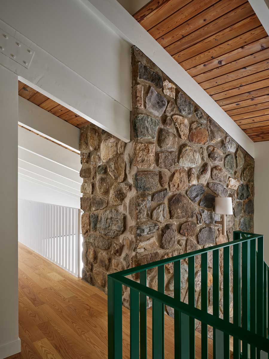 Kombinace původní kamenné stěny a nových dřevěných prvků krásně vystihuje propojení tradice a moderního stylu, které rekonstrukce přinesla.