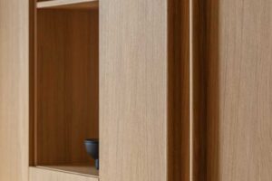 Vestavěná dubová skříň s minimalistickými úchyty v klidném interiéru rodinného domu