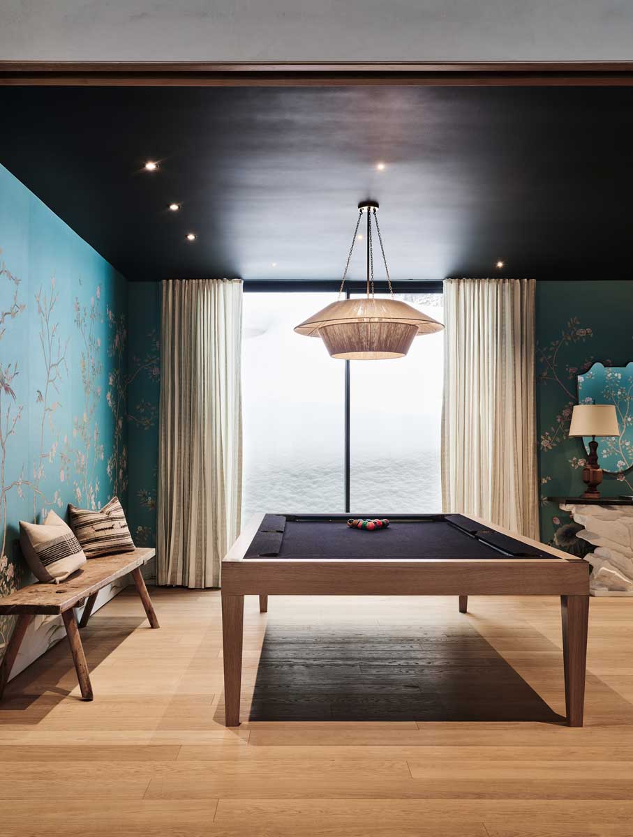 Designová herna s kulečníkovým stolem a jemnou květinovou tapetou.