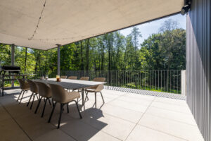 Terasa s jídelním stolem a výhledem do korun stromů.