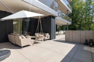 Relaxační terasa s pohodlným posezením, houpačkou a slunečníkem.