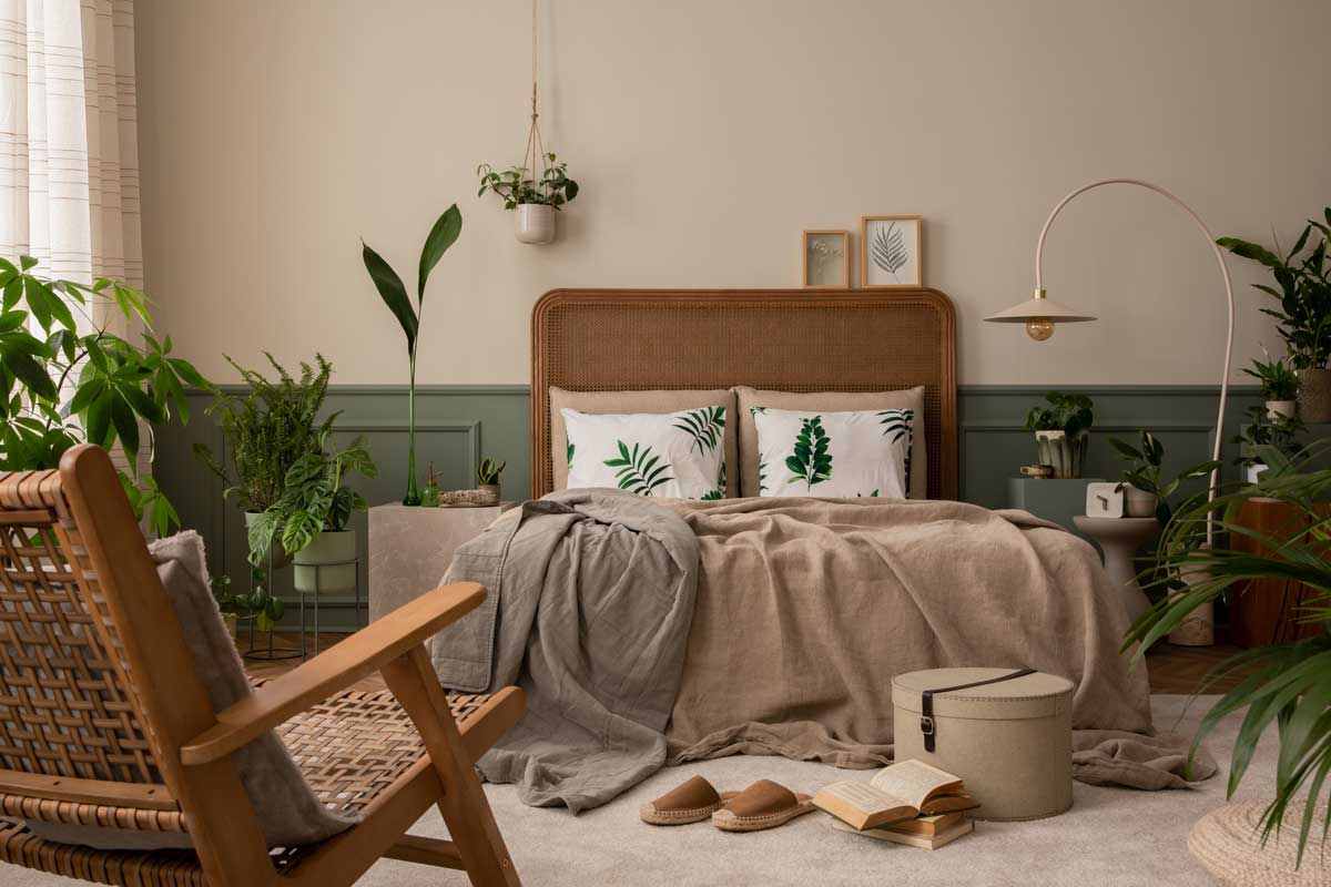 Uvolněná ložnice s přírodními materiály, zelenými rostlinami a nenucenou atmosférou skutečného bydlení.