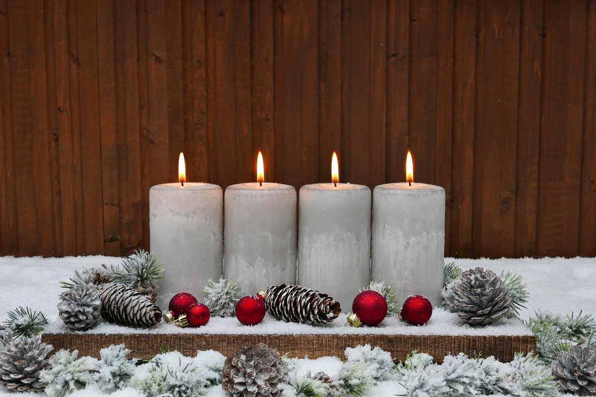 Moderní obdélníkový adventní věnec se čtyřmi bílými svíčkami, světlými ozdobami a jednoduchým jehličím působí čistě a elegantně.