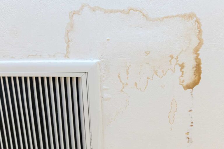 Skvrny kolem ventilační mřížky naznačují zatékání zvenčí nebo problémy s odvodem vlhkosti