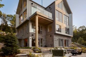 Spodní terasa s kamennými stupni a vířivkou propojuje dům La Croix s přírodní zahradou zakotvenou v lesním svahu