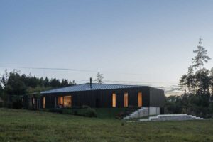 Zahrada kolem moderního domu s terasami a výhledem do krajiny