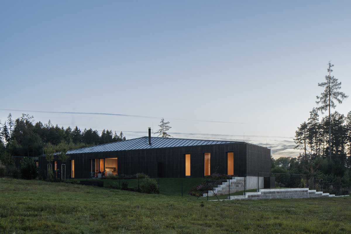 Zahrada kolem moderního domu s terasami a výhledem do krajiny