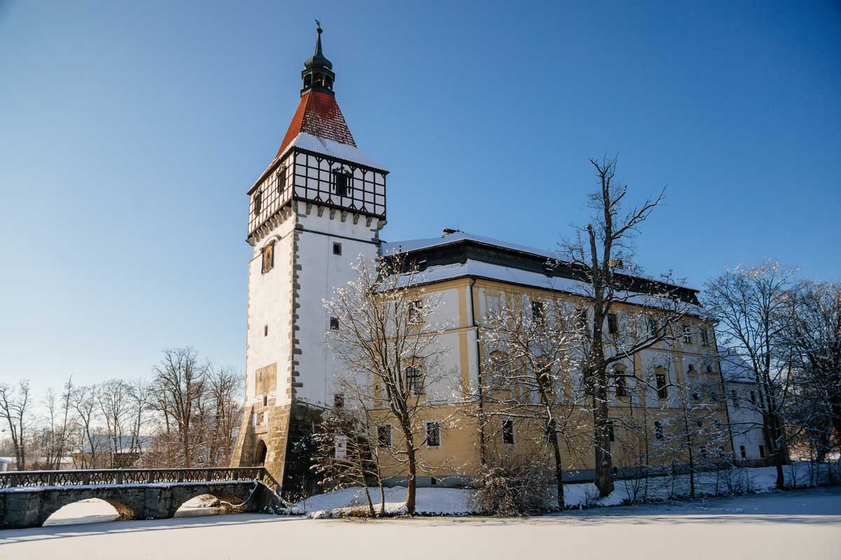 Zámek Blatná v zimním období se zasněženým parkem