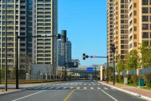 Prázdná široká ulice mezi novými obytnými věžovými domy v Jiaxingu.