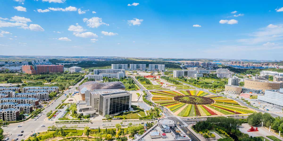 Letecký pohled na rozlehlé urbanistické centrum Ordosu s minimem obyvatel.