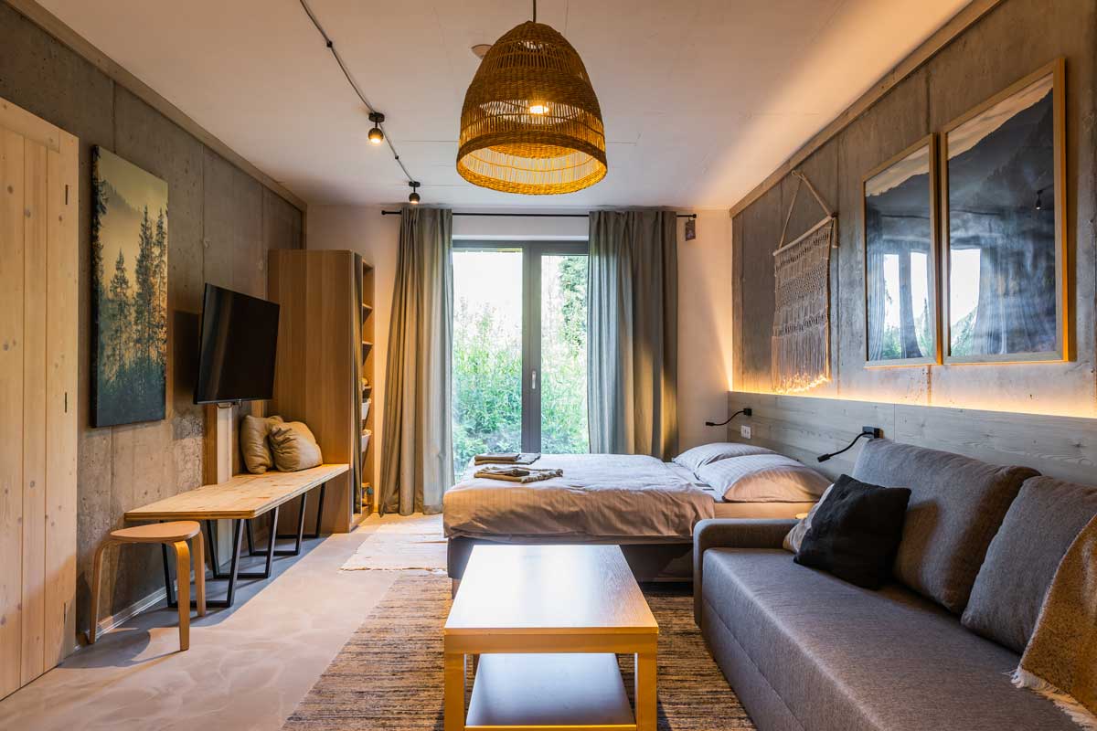 Interiér apartmánu s dřevěnými trámy a otevřeným úložným prostorem