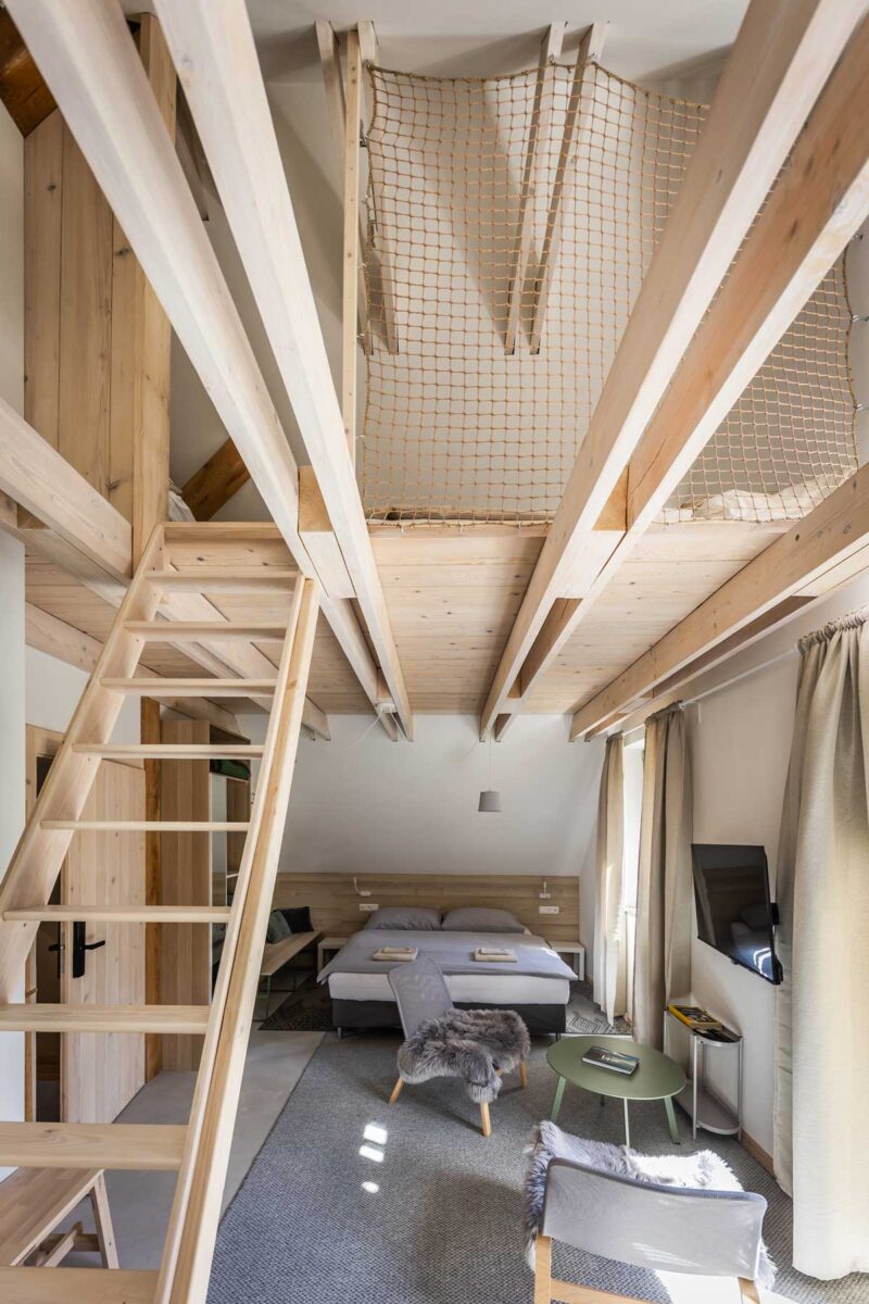 Mezonetový pokoj v chatě s dřevěným schodištěm a loftem