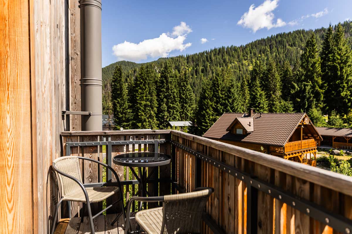 Balkon chaty s posezením a výhledem na horskou krajinu