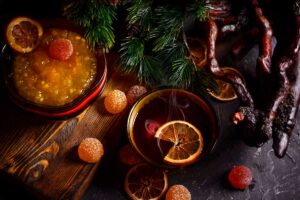 Šálek horkého čaje s marmeládou a kořením, podávaný na dřevěné desce.