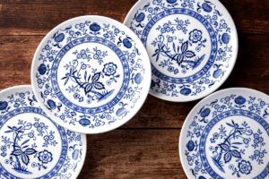 Detail tradičního cibulového vzoru na porcelánovém talíři v modrobílé kombinaci s typickými stylizovanými motivy