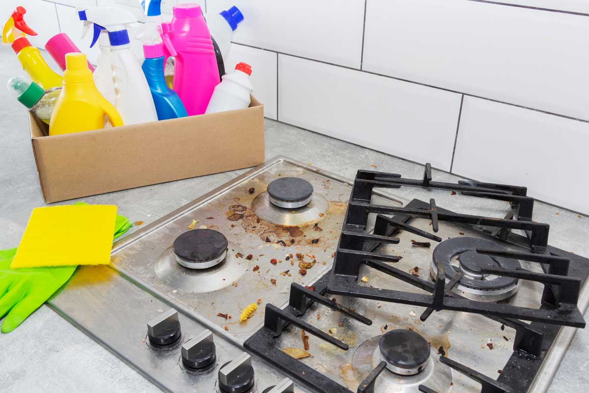 Znečištěný plynový sporák připravený na důkladné čištění s domácími odmašťovacími prostředky
