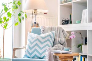 Světlý čtecí koutek s pohodlným křeslem a poličkami – ideální introvertní útočiště.