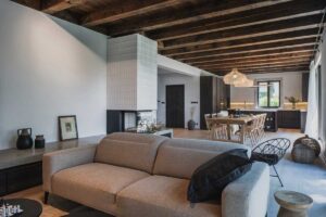 Otevřená denní zóna s kuchyní, jídelnou a obývacím pokojem v horské chalupě